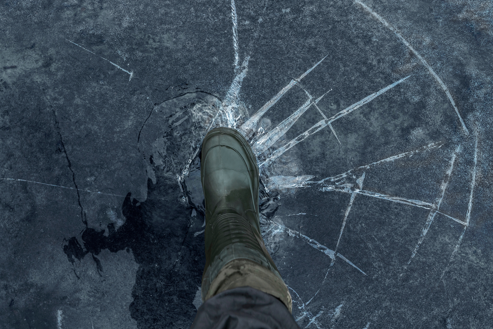 Foot pushing on broken frozen lake