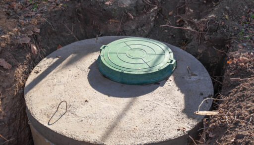 Close-up of a partially buried septic tank.
