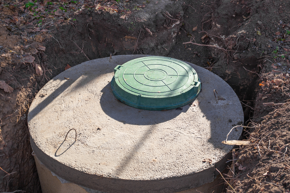 Close-up of a partially buried septic tank.
