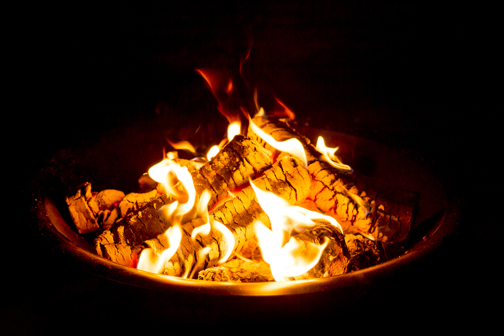 Close-up of a fire pit burning at night.
