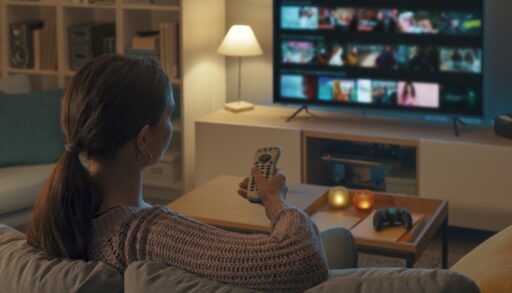 Woman holding a remote watching TV.
