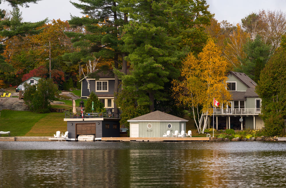 Cottages next to a shoreline with a Canadian flag.