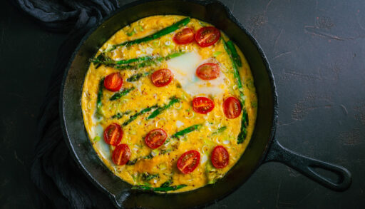 Overhead view of an asparagus frittata with cherry tomatoes.