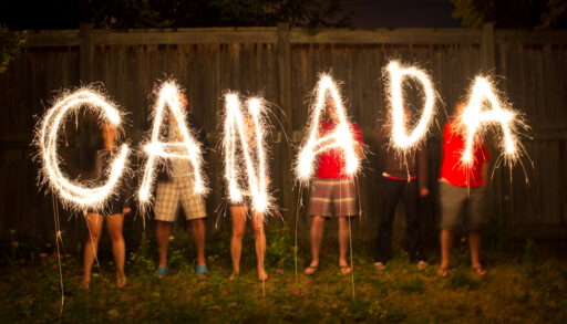 People holding sparklers spelling Canada.