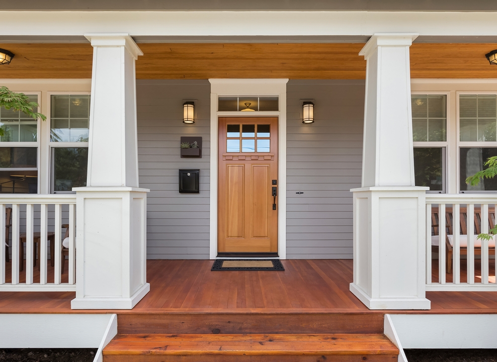 Front view of a wooden door with a white and wood porch.