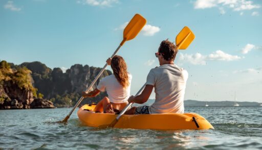 Man and woman paddling a yellow kayak.