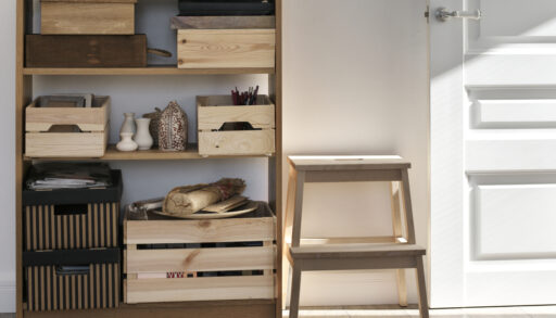Wooden shelf with wooden crates next to a wooden step stool.