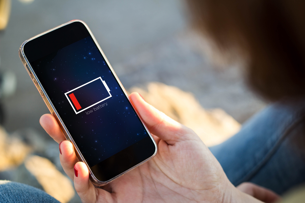 Close-up of a person's phone screen with a low battery indicator.