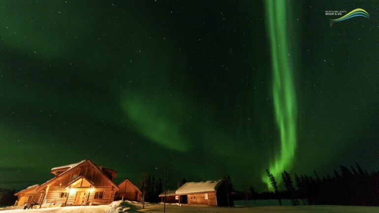 Northern lights over log cabins