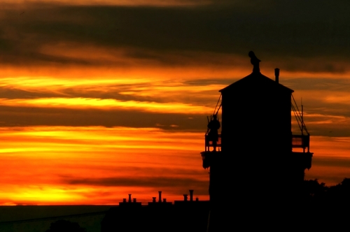 Orange sunset behind the silhouette of the Kincardine Lighthouse in Kincardine, Ontario.