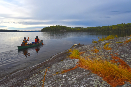 Two people paddle a canoe in Quetico Provincial Park, Ontario.