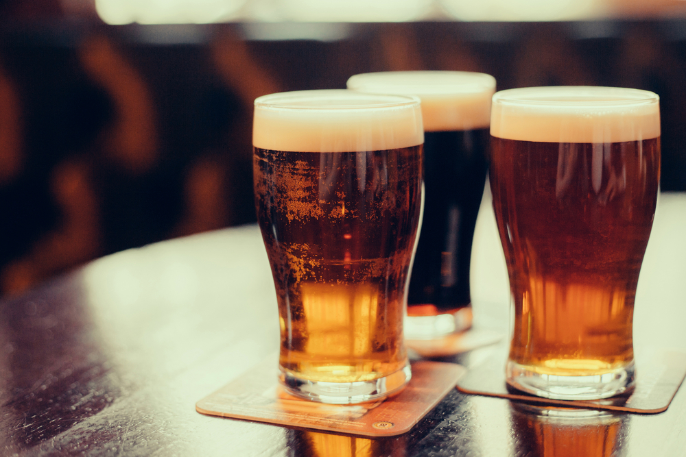 Close-up of three dark-coloured beers.