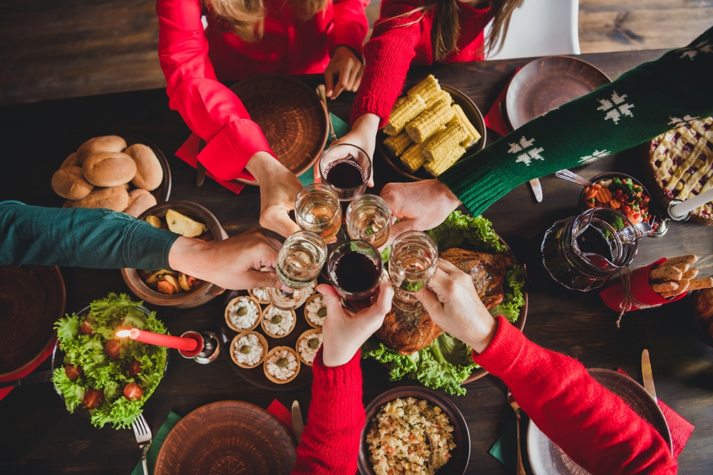 Top-view of people celebrating the holidays and drinking champagne.