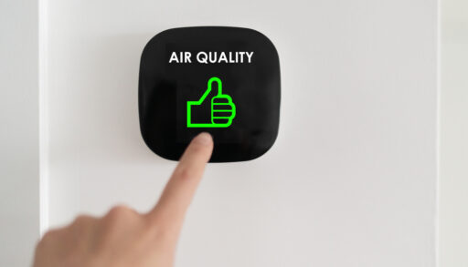 Close-up of a person pressing an indoor air quality monitor.