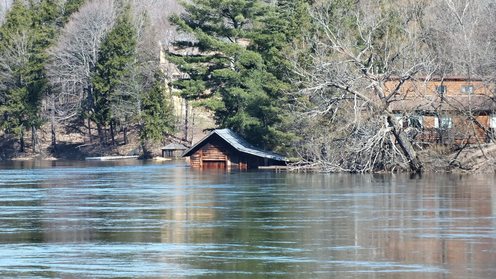 Wooden cottage partially submerged in water during spring flooding in Huntsville, Ontario in 2013.