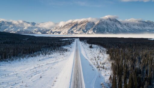 Ariel view of mountain and tree landscape with a road in the middle in Whitehorse, Yukon, Canada.