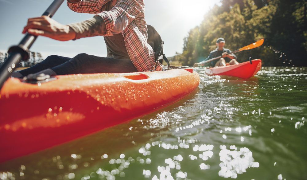 Close-up of two people canoeing on a sunny lake.