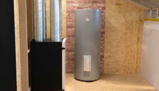 Grey hot water tank in an unfinished basement.