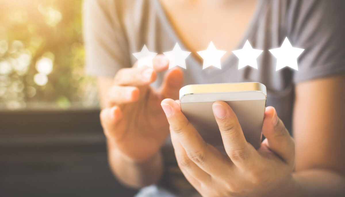 a person submitting a five-star review on their phone