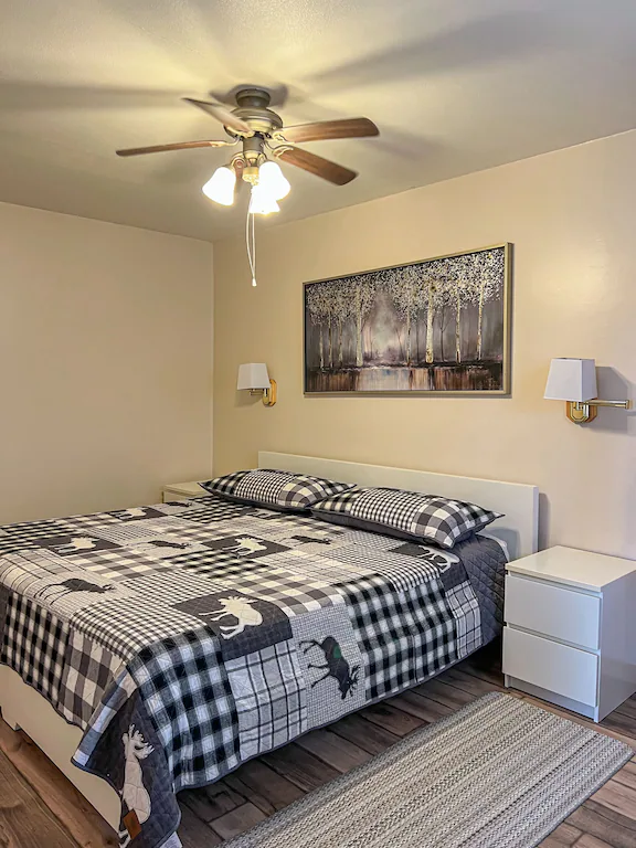 Cottage bedroom with bed and ceiling fan.