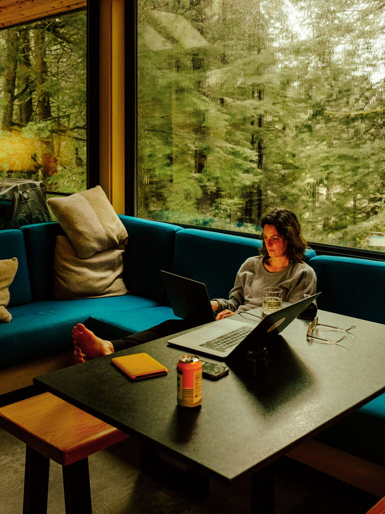 Woman in kitchen sitting on couch
