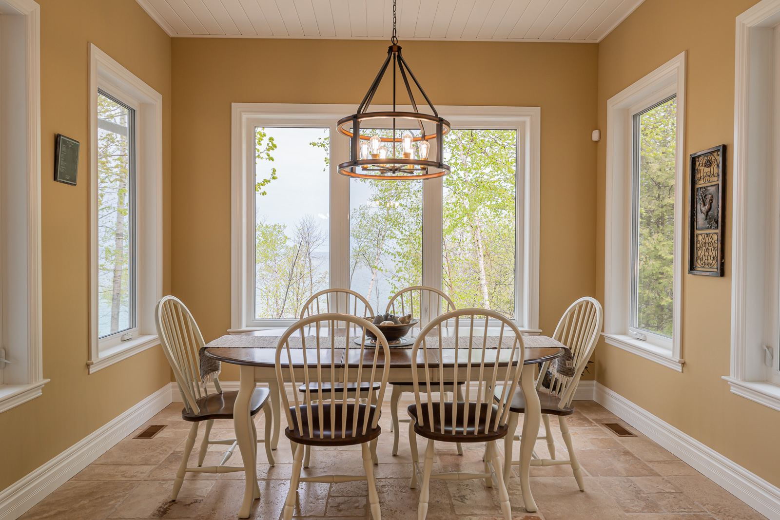 A nook with a table and chairs and lots of windows.