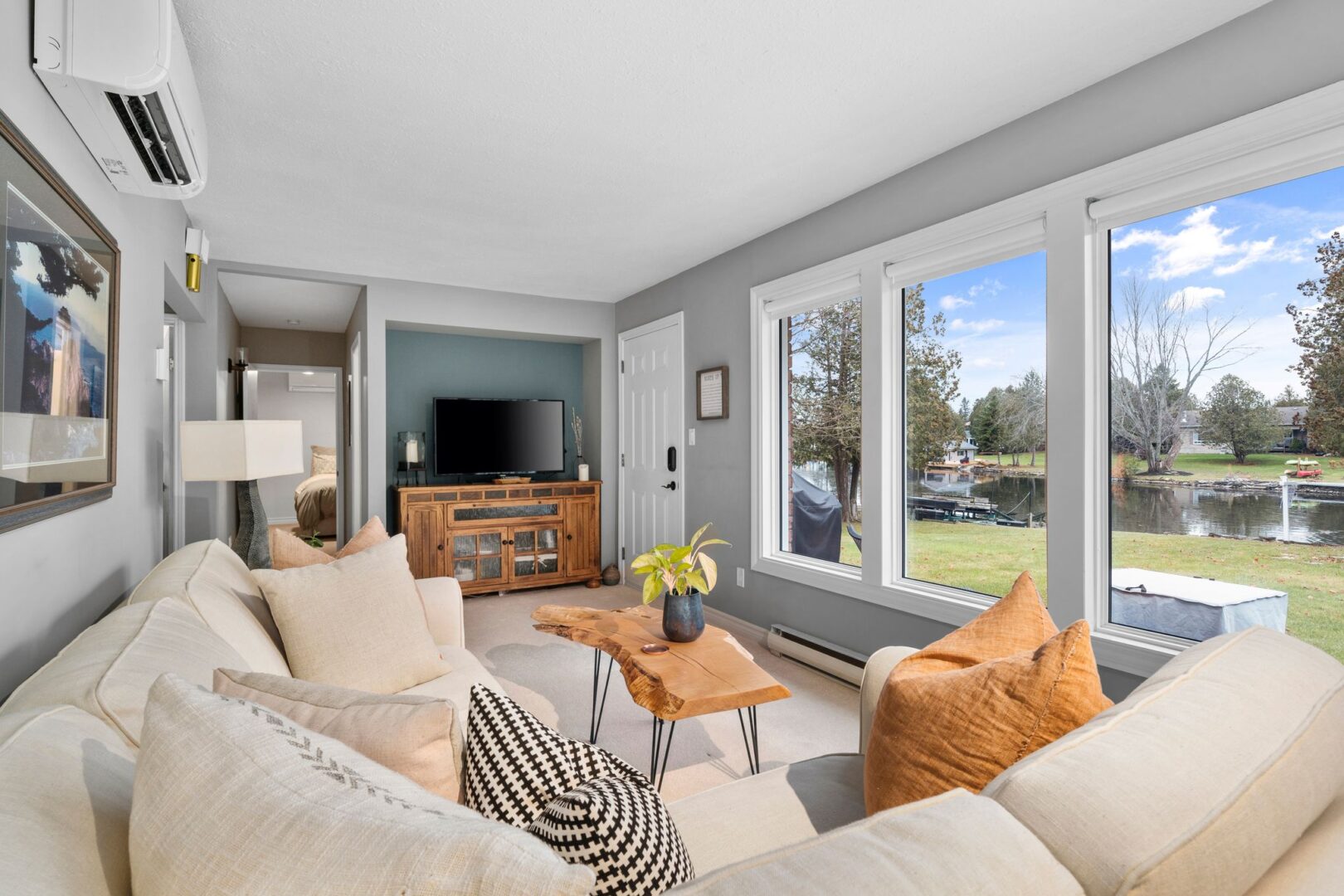 A bright and cozy living area with a large window and a big, white sectional couch.