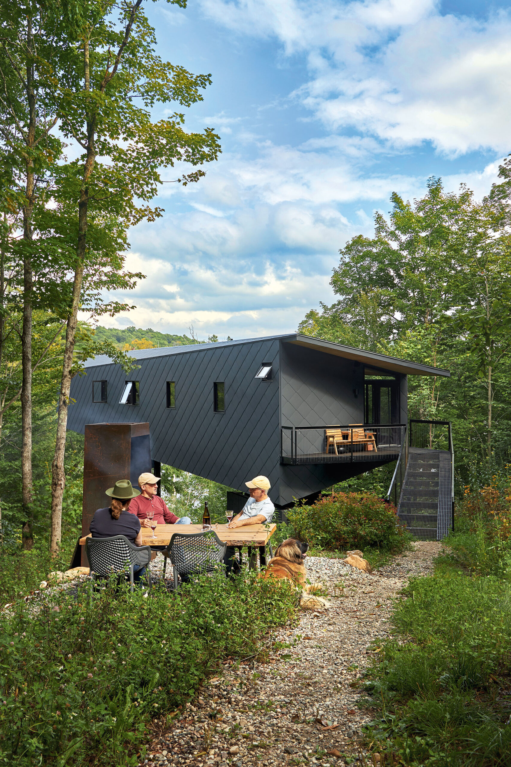 Tony, Paul, Jethro, and a friend sit around a wood table outside the bat cabin