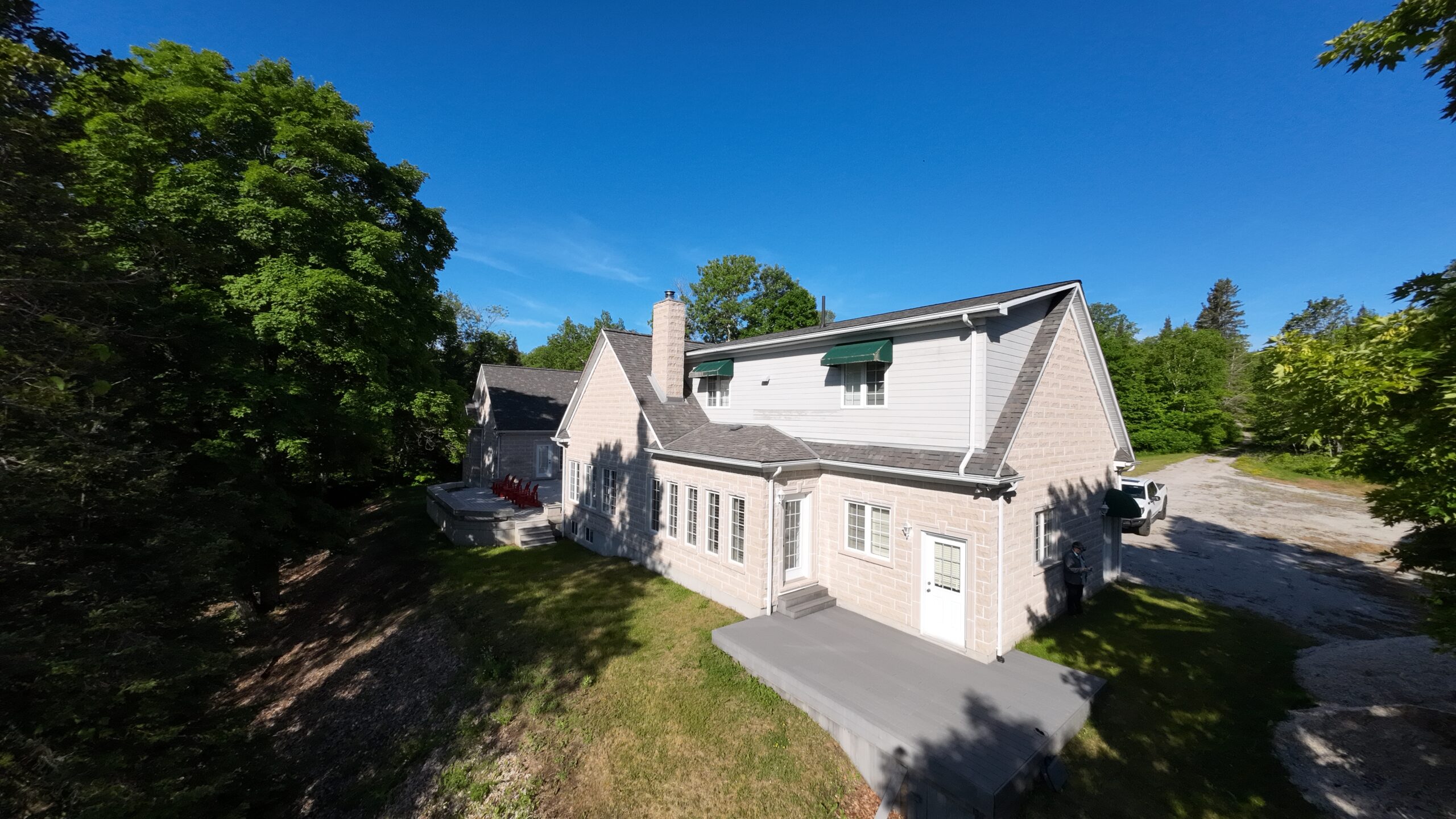 Another angle of the back of the house with a small grey deck