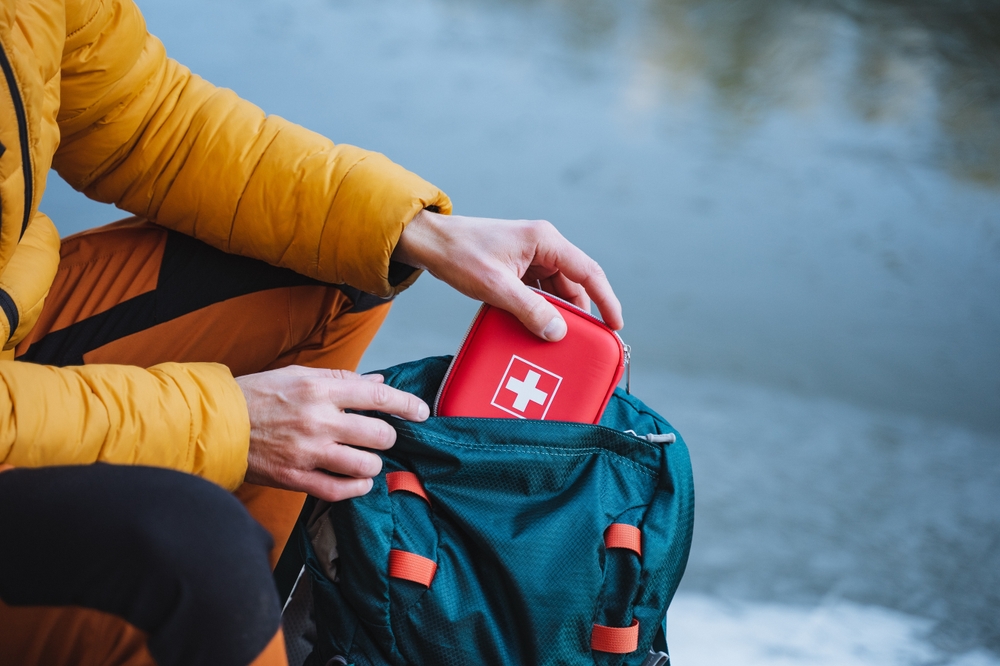 Person putting first aid kit into a bag