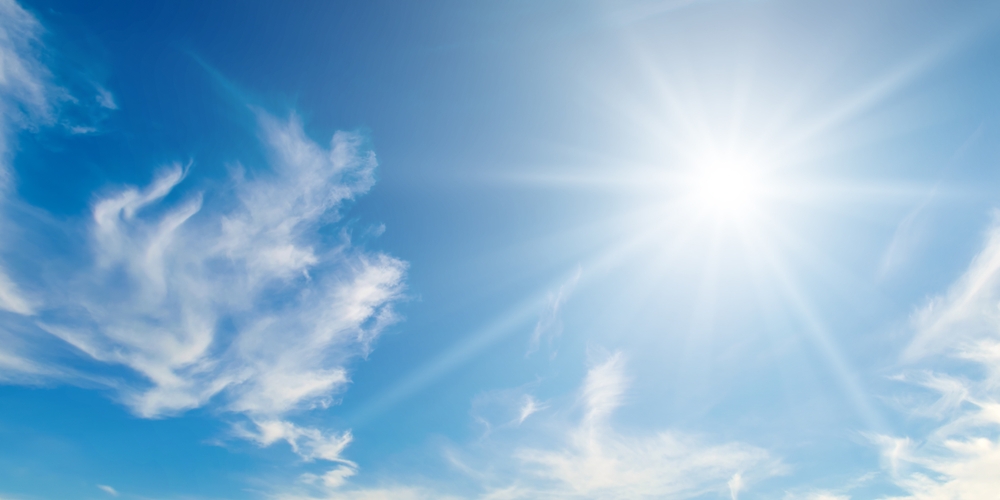 Blue sky with sun and clouds