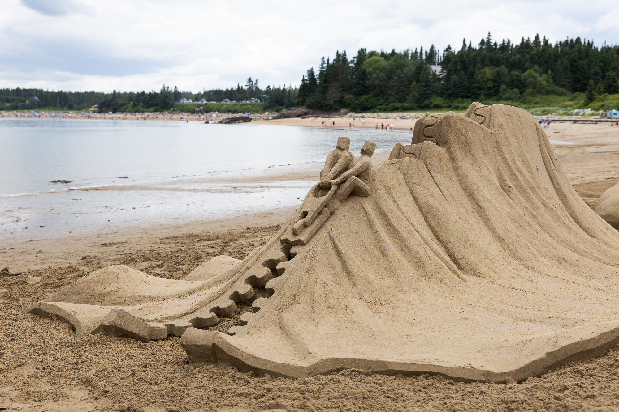 A sand sculpture of a mountain, with a zipper detail