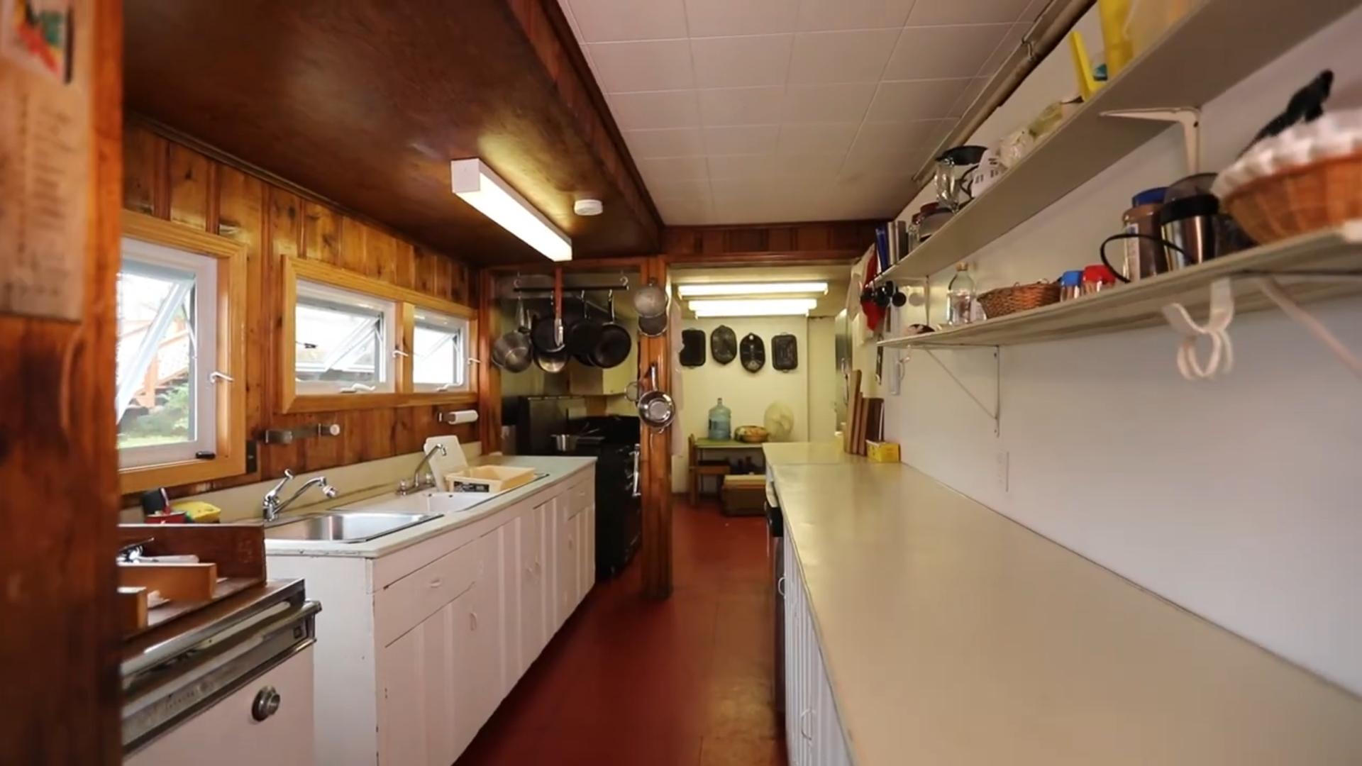 A narrow kitchen with white cabinets