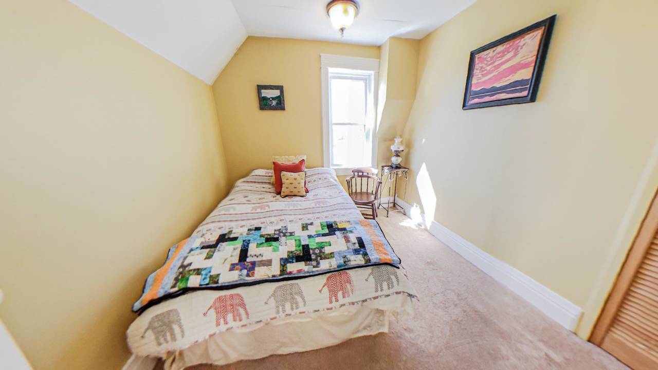 A quilted bed in the corner of a cream room
