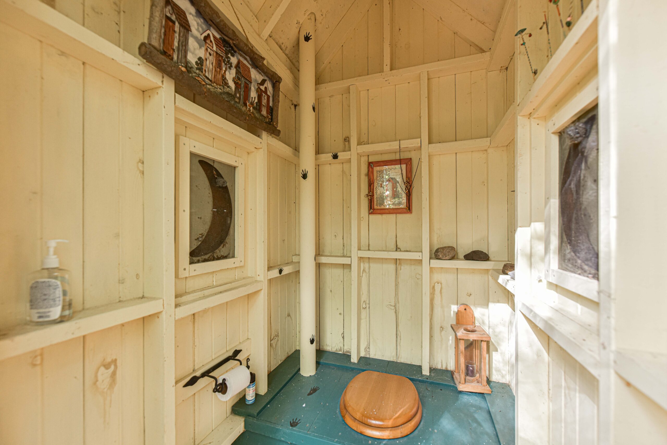 A white room with a teal seat and a small wooden toilet cover