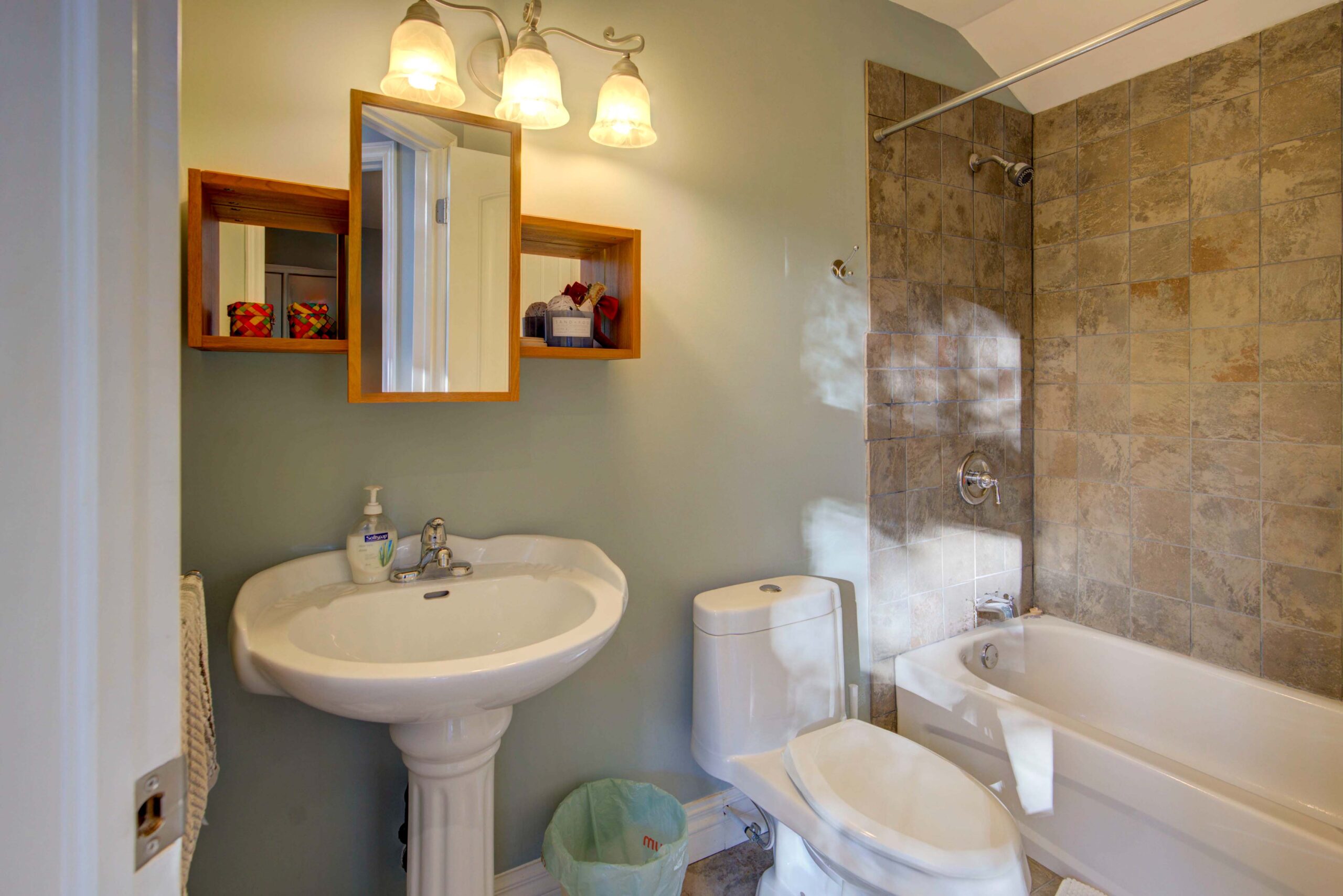 A small blue bathroom. A white sink is beside the white toilet