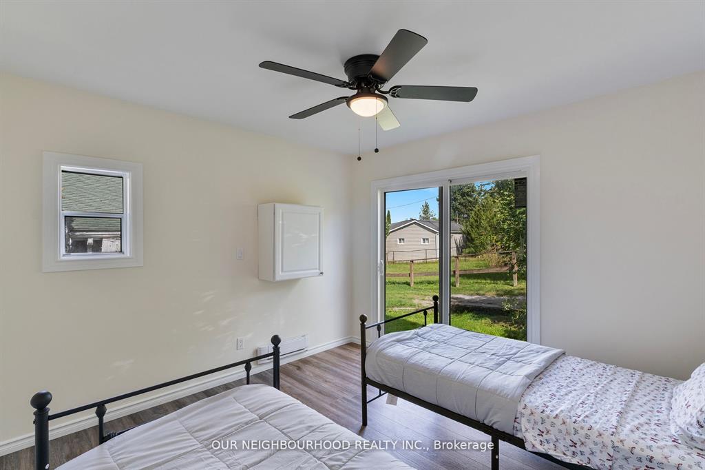 Two white beds on metal bed frames in a white room