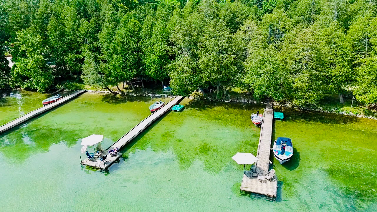 A stunning lakefront view featuring multiple docks and calm blue waters.