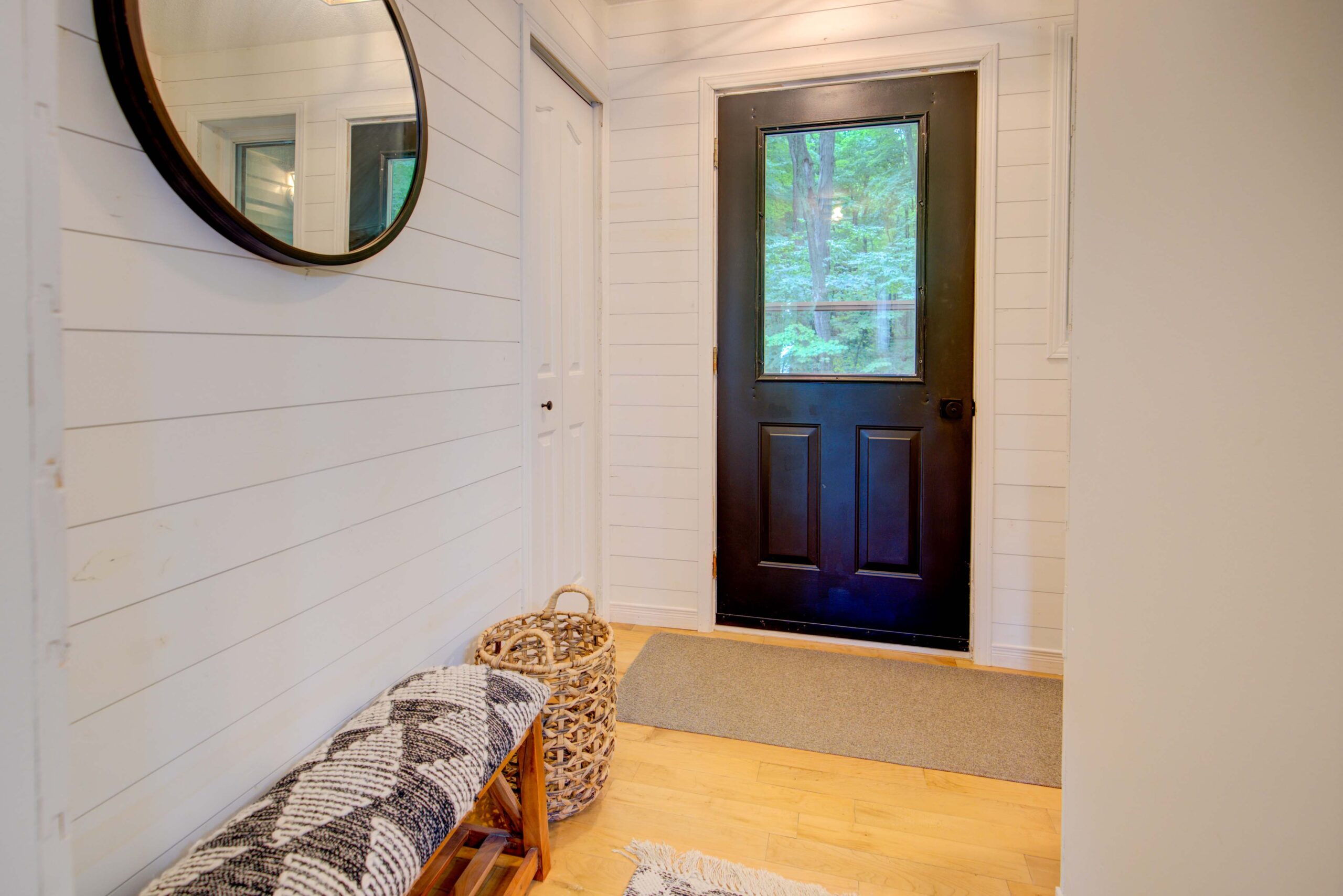 A spacious wood living room with couches. An open-concept wood loft is on the upper level