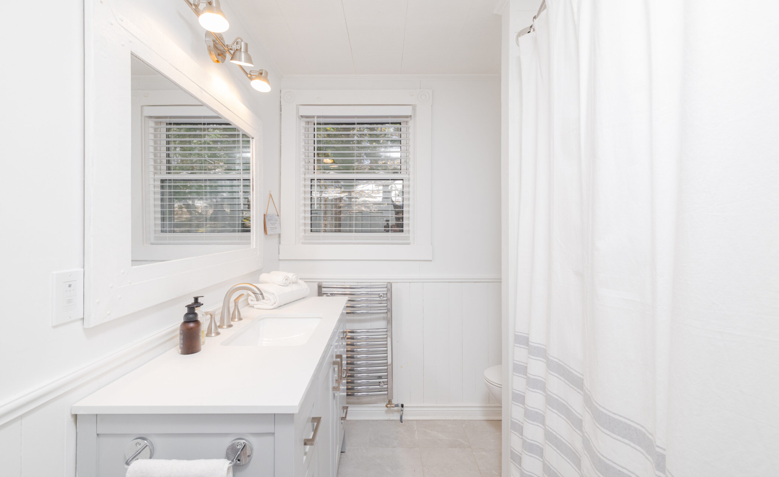 A white bathroom with a light grey vanity