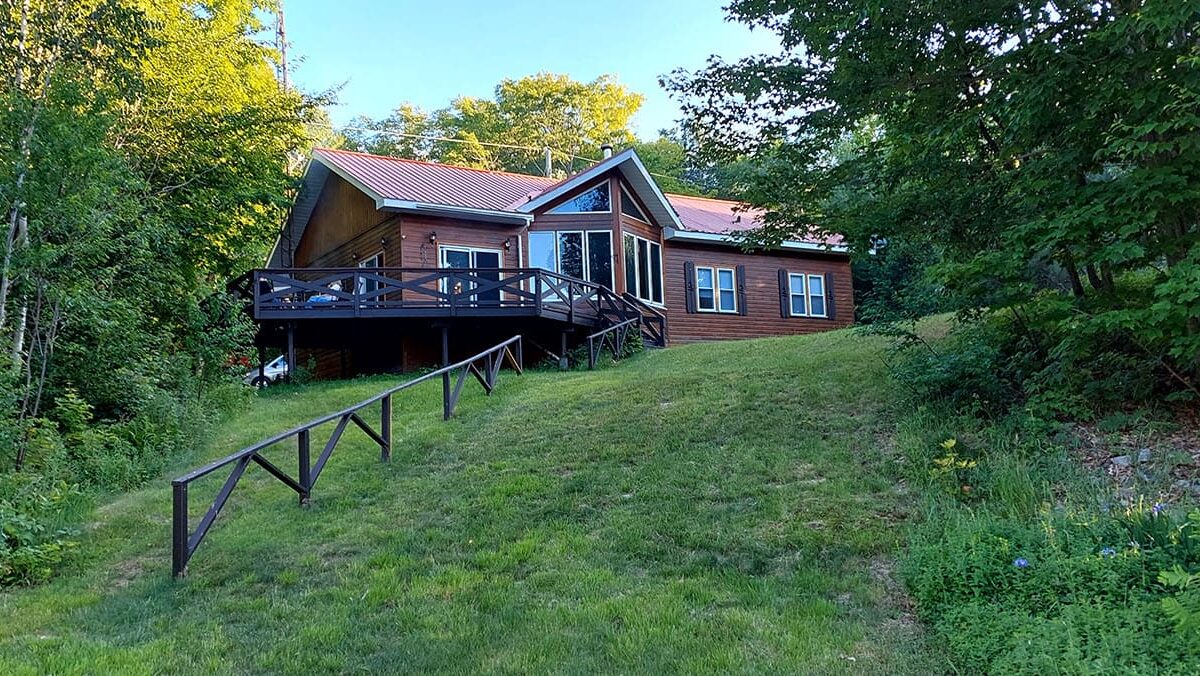 A wood cabin on a grassy lawn