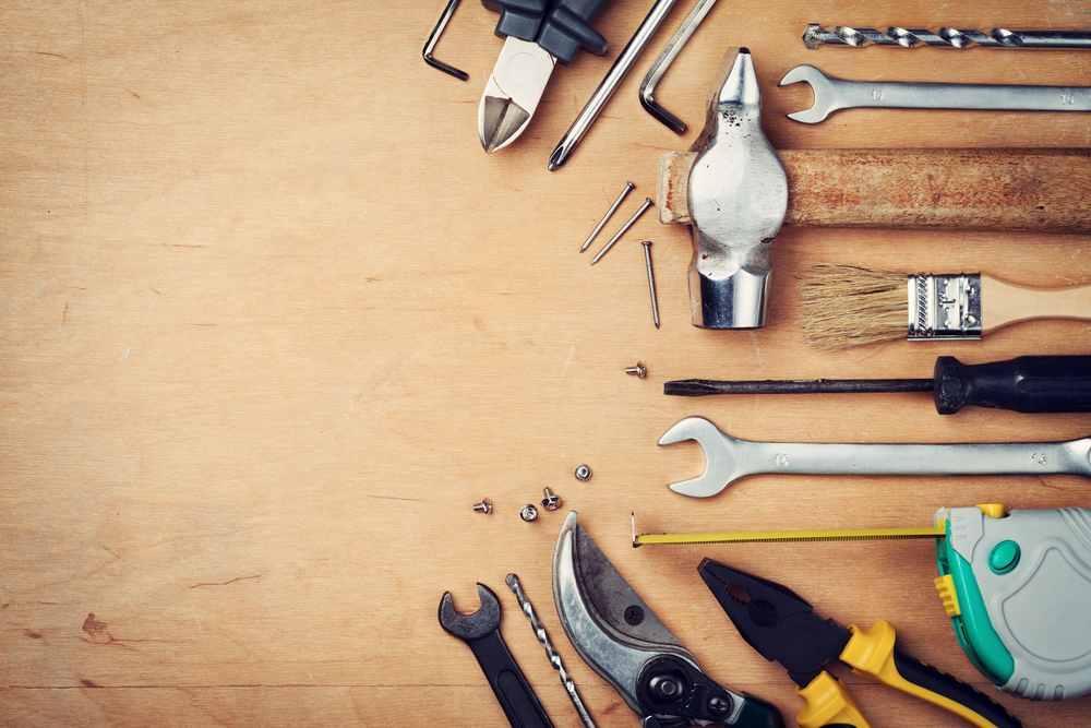 A collection of tools against a wood background