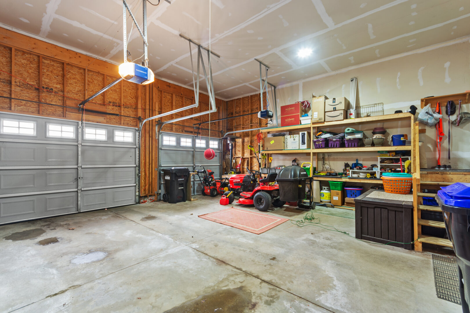 A spacious two-car garage with storage along the walls