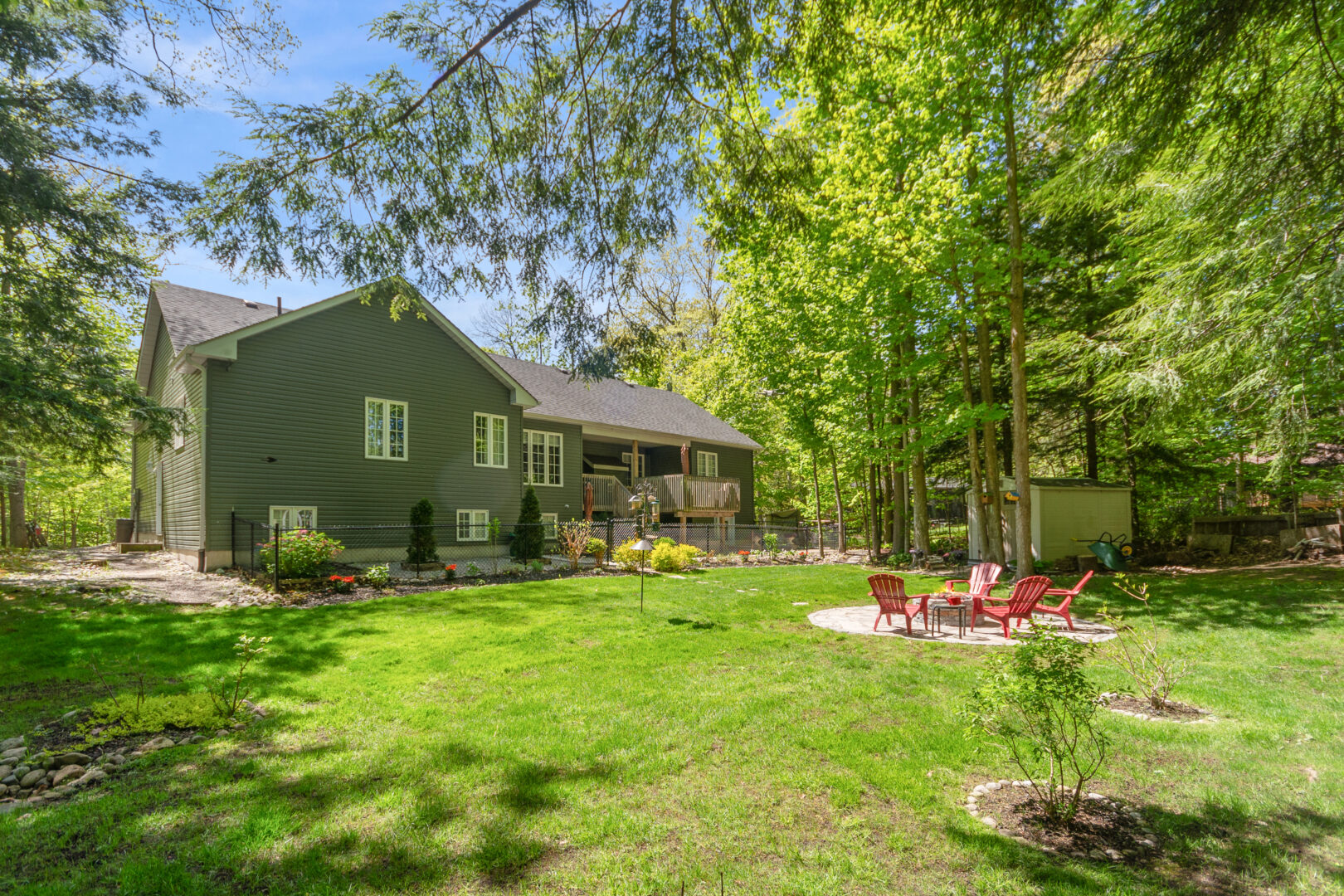 A spacious backyard by a large green paneled cottage