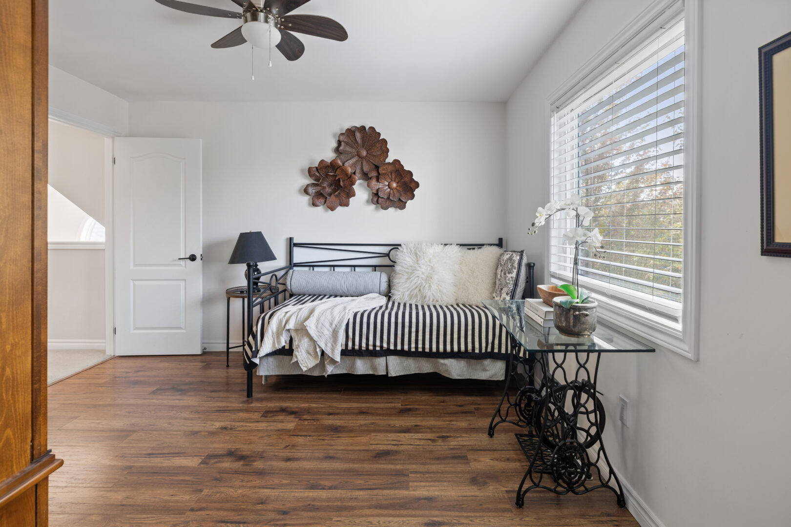 A white bedroom with a wire frame bed