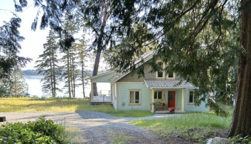 Wooded front entry of west coast-style cottage overlooking the water