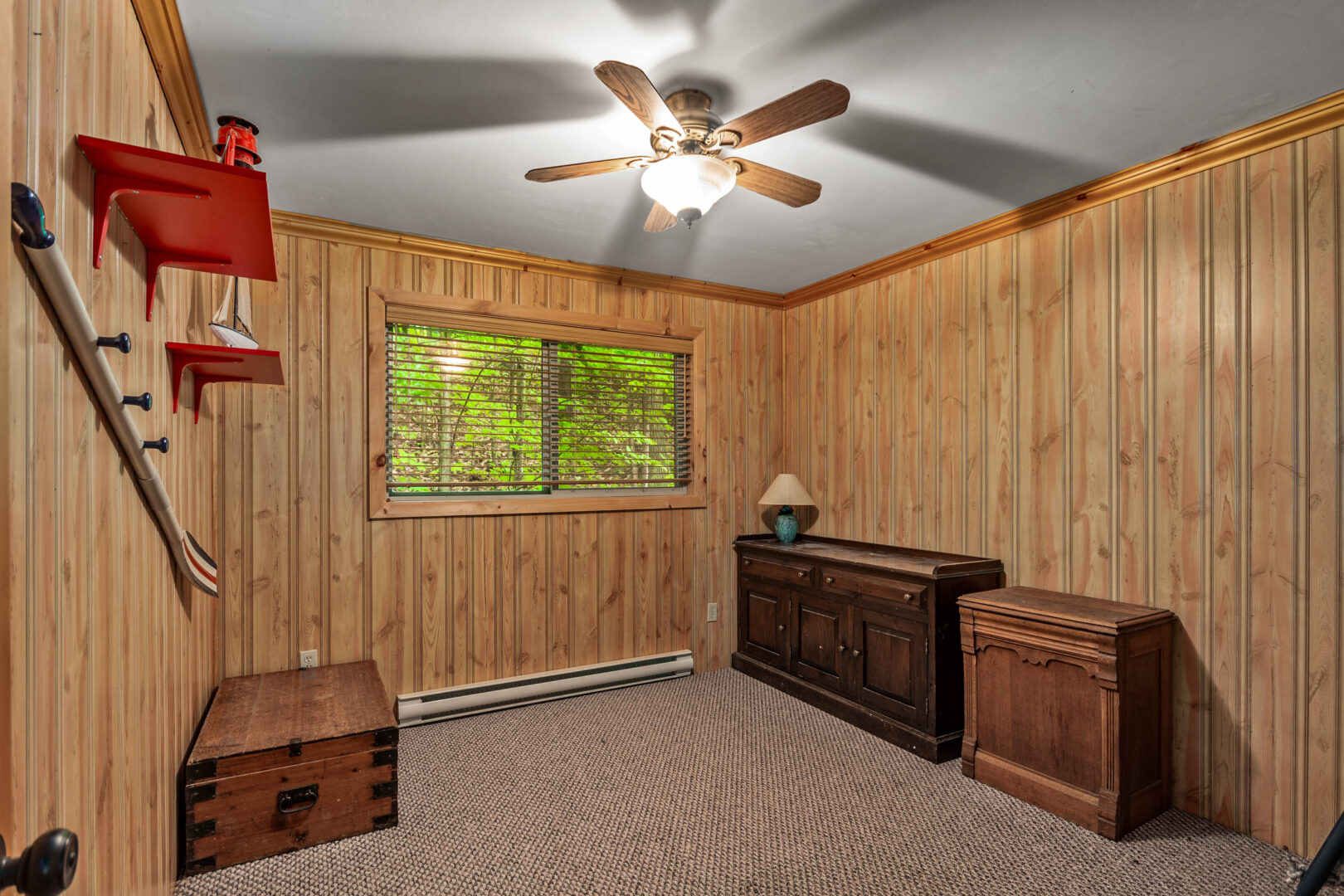 A wood paneled room with wood chests along the walls
