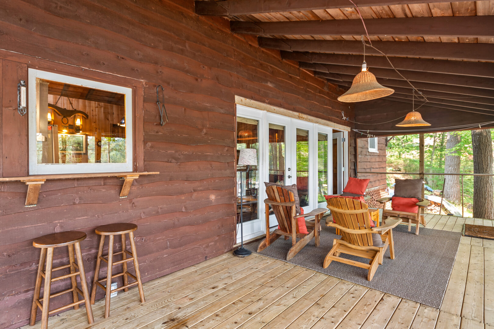 Wood Muskoka chairs face each other on a wood deck