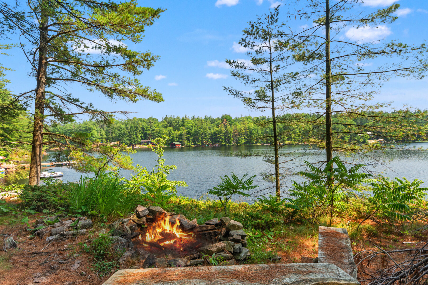 A burning fire pit next to a lake