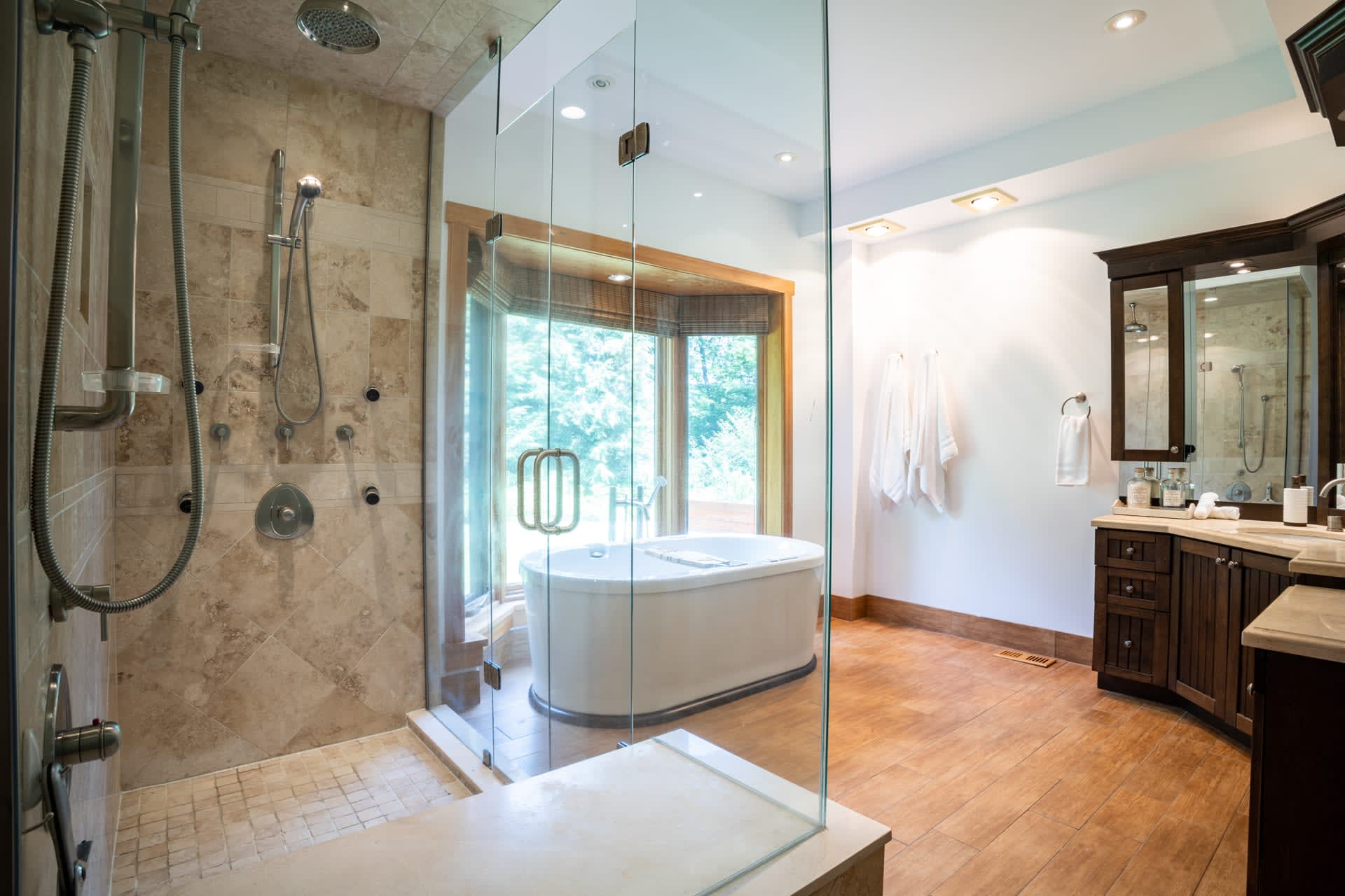 A large white bathroom with a freestanding tub and a glass walk-in shower